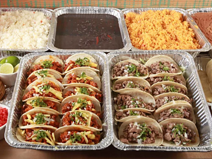 Foil catering trays filled with food, rice and beans ready for a party